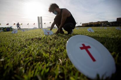 Integrantes de la ONG Rio da Paz colocan platos con cruces rojas durante un acto para protestar por el hambre que los brasileños experimentarán por falta de dinero, frente al edificio del Congreso Nacional, en Brasilia (Brasil). Los platos colocados en el césped simbolizan el número total de diputados (513) y senadores (81). 