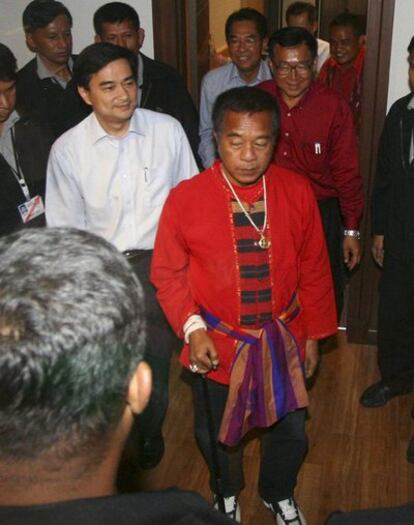 El primer ministro tailandés, Abhisit Vejjajiva (izquierda), entra detrás del líder de los <i>camisas rojas</i> Veera Musikapong a la reunión para tratar de acabar con la crisis política, hoy en Bangkok.