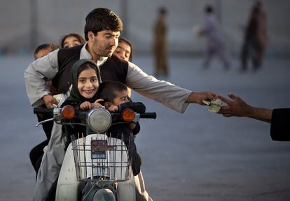 Un hombre junto a cinco niños en una motocicleta para la entrada de un parque en Kandahar (Afganistán), 1 de noviembre de 2013.