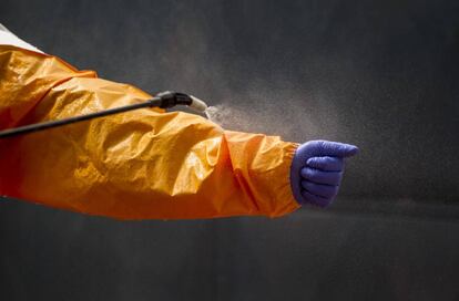 Un miembro del equipo de funerarios voluntarios en Guinea se desinfecta tras transportar el cuerpo de una fallecida por ébola. Enero de 2015.