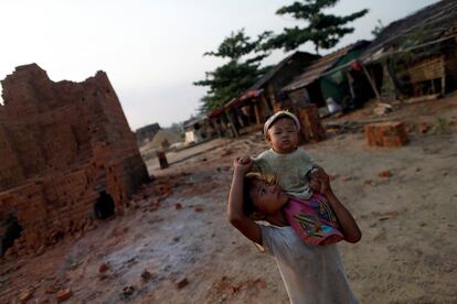 Dos niños pasan el tiempo en la calle mientras sus padres trabajan en un horno de ladrillo en las afueras de Rangún, Birmania.