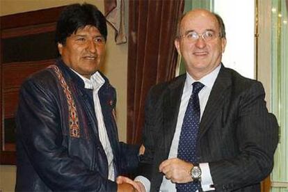 Evo Morales (a la izquierda) y Antonio Brufau se estrechan la mano ayer en La Paz.