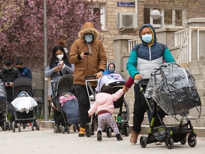 Varias familias esperan en una cola del hambre en la Parroquia Santa Maria Micaela y San Enrique de Madrid.