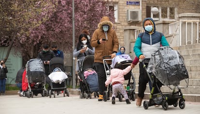 Families wait in line for food donations outside the Santa María Micaela y San Enrique church in Madrid.