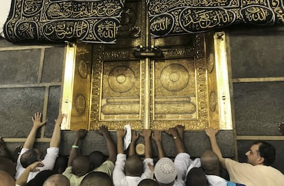 Un grupo de devotos musulmanes toca una parte de la Kaaba, que representa el lugar más sagrado del islam y el destino de peregrinación religiosa más importante.
