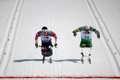 Sin Eui-hyun (i) de Corea del Sur y Dzmitry Loban (d) de Bielorrusia cruzan la línea de meta en el biathlón, el 13 de marzo de 2018.