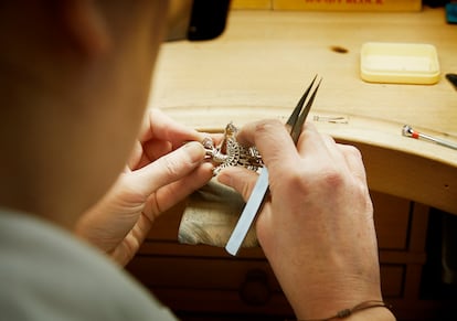 Un artesano rematando una pieza en forma de bailarina.