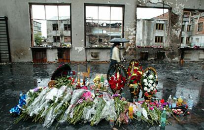 Varios ramos de flores se amontonan en el centro del gimnasio del colegio. Las botellas recuerdan el agua que negaron los terroristas a los niños.