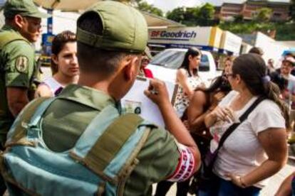 Miembros de la Guardia Nacional venezolana fueron registrados este lunes al anotar el nombre de algunas personas que esperan realizar compras en una de las sedes de la cadena de tiendas Daka, en Caracas (Venezuela).