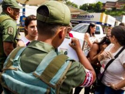 Miembros de la Guardia Nacional venezolana fueron registrados este lunes al anotar el nombre de algunas personas que esperan realizar compras en una de las sedes de la cadena de tiendas Daka, en Caracas (Venezuela).