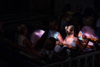 Varias personas se abanican para mitigar el intenso calor durante la representación del Misteri d'Elx en la Basílica de Santa María de Elche. 
