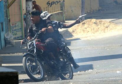 Un policía dispara contra los manifestantes ayer en Santo Domingo.