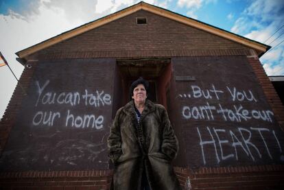 Linda Restaino posa delante de su casa, con una pintada realizada por su hijo en la nueva tapia. Restiano, que ha vivido en New Dorp durante 35 años, espera poder dejar Staten Island.
