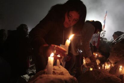 Familiares de los trabajadores encerrados encienden velas en el exterior de la mina, en Copiapó.