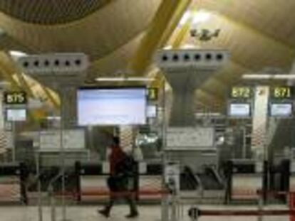 Un hombre pasa junto a los mostradores de facturación de Iberia en la T4 de Barajas.