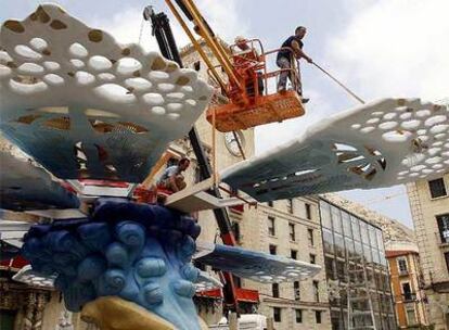 Operarios del taller del artista Francisco José Esplá ensamblan piezas de la hoguera de la plaza del Ayuntamiento.