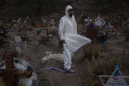 Un empleado del cementerio de Chalco (México) con un equipo de protección frente al coronavirus. Una semana después del inicio de la llamada "nueva normalidad", el "semáforo" que mide la evolución del virus por Estados mantiene a todo el país en rojo, es decir, en riesgo máximo.