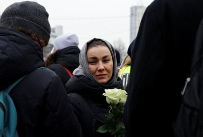 Una mujer sujeta claveles blancos en el exterior de la iglesia moscovita, este viernes. 