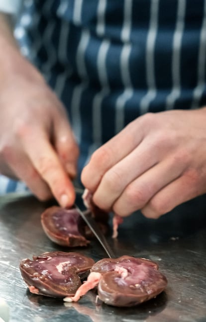 A cook tweaks some kidneys, an ingredient in one of the house's signature dishes. 