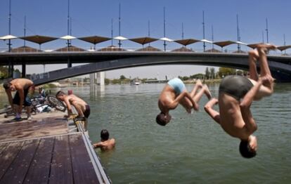 Un grupo de jóvenes se baña en el Guadalquivir.