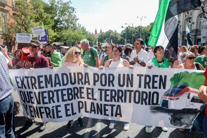 Un grupo de personas sostiene una pancarta durante una concentración por un tren “digno” para Extremadura, frente al Congreso de los Diputados.