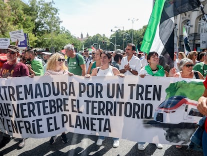 Un grupo de personas sostiene una pancarta durante una concentración por un tren “digno” para Extremadura, frente al Congreso de los Diputados.