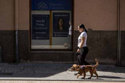 Un mujer pasea a su perro en Ripoll frente a la sede de Aliança Catalana.