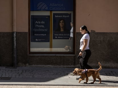 Un mujer pasea a su perro en Ripoll frente a la sede de Aliança Catalana.