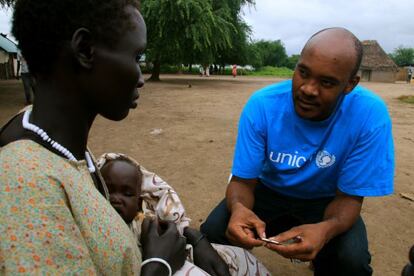El doctor Thoms Lyimo habla con Nyakuoch Keat, madre de un bebé de nueve meses que tiene síntomas de malaria.