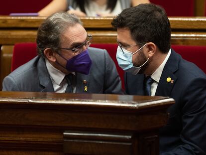 A la derecha, el presidente catalán, Pere Aragonès, conversa con el conseller de Economía y Hacienda, Jaume Giro, durante el pleno del Parlament este jueves.