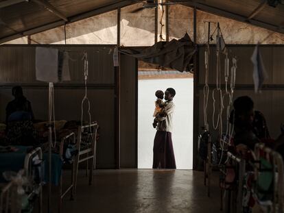 Nyukouth sostiene a su hermana Nyawan en el hospital de MSF en el campo de Bentiu. Tenía neumonía y fiebre alta, pero se está recuperando bien.