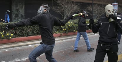 Un manifestante lanza un cóctel molotov a la policía griega en Atenas, durante la jornada de huelga general que vive Grecia.