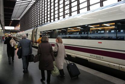 Varios pasajeros con maletas bajan del Ave Barcelona-Madrid a su llegada a la estación de Atocha (Madrid). En el andén un tren Siemens