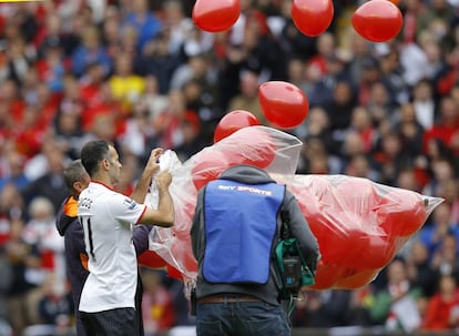 Ryan Giggs ayuda a liberar 96 globos rojos.