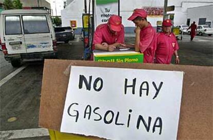 Los empleados de una gasolinera desabastecida por la huelga matan el tiempo ayer en Caracas.