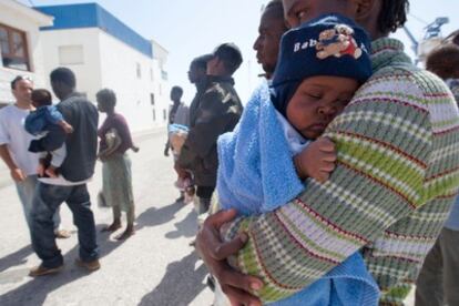Inmigrante subsahariana a su llegada a la costa de Motril (Granada) con su hijo en brazos.