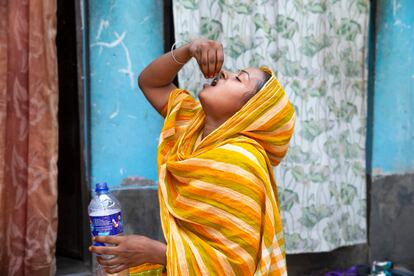 A tuberculosis patient takes her medication at home in Dhaka, Bangladesh.