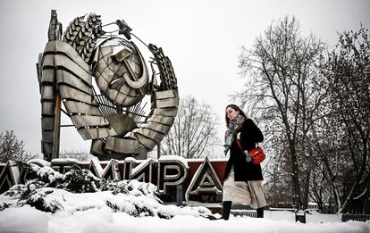 Una mujer pasa junto a un emblema estatal de la URSS en un parque de esculturas de historia moderna en Moscú, en diciembre de 2021.