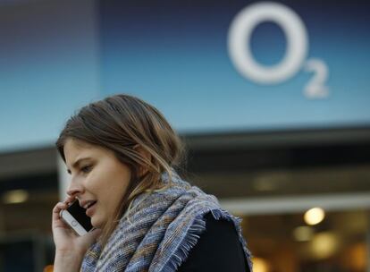 Una usuaria habla por su m&oacute;vil junto a una tienda de O2.