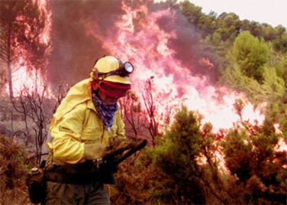 Un miembro de la Brigada Antiincendios huye de las llamas descontroladas en Chiva, Valencia.