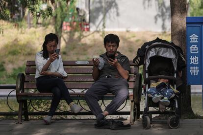 Una familia descansa en un banco en un parque en Pekín el 5 de mayo.