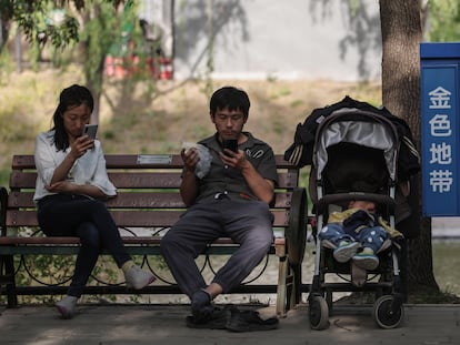 Una familia descansa en un banco en un parque en Pekín el 5 de mayo.