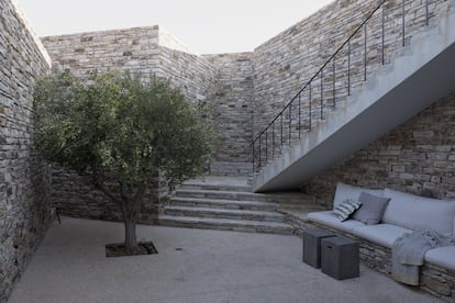 Los arquitectos plantaron olivos y eucaliptos para añadir sombra y vegetación a la vivienda. Los rincones exteriores aprovechan desniveles del muro para ubicar bancos. Los cojines son de Bonden Living.