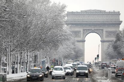 El tráfico en la avenida de los Campos Eliseos en París, debajo del Arco del Triunfo, cubierta de nieve, este miércoles.