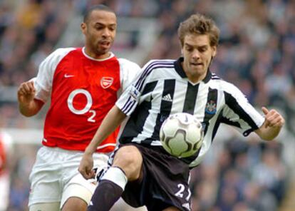 Woodgate controla el balón ante Henry, en un Newcastle-Arsenal de la Liga inglesa.