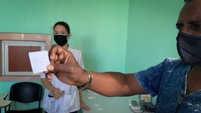 Un hombre perteneciente al sistema de Salud cubano a la espera de ser vacunado con la vacuna cubana Soberana 02 muestra su control de temperatura, el 24 de marzo, en La Habana.