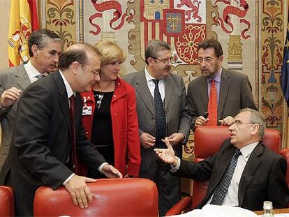 Varios diputados hablan con el presidente de la Comisión Constitucional, Alfonso Guerra, a la derecha.