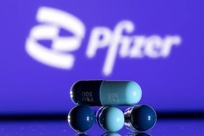 El logo de Pfizer junto a unas píldoras fabricadas por la empresa