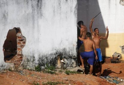 Detentos gesticulam para a polícia, que assiste de fora à movimentação em Alcaçuz em janeiro de 2017