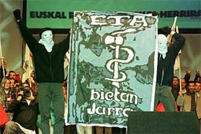 Dos encapuchados muestran una pancarta de ETA en un acto de Gestoras pro Amnistía en 1999.